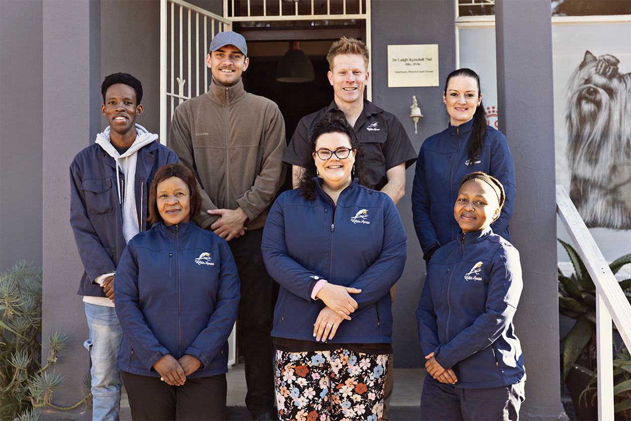 The friendly and professional veterinary and boarding staff team standing outside The Robin House dog hotel in Benoni.