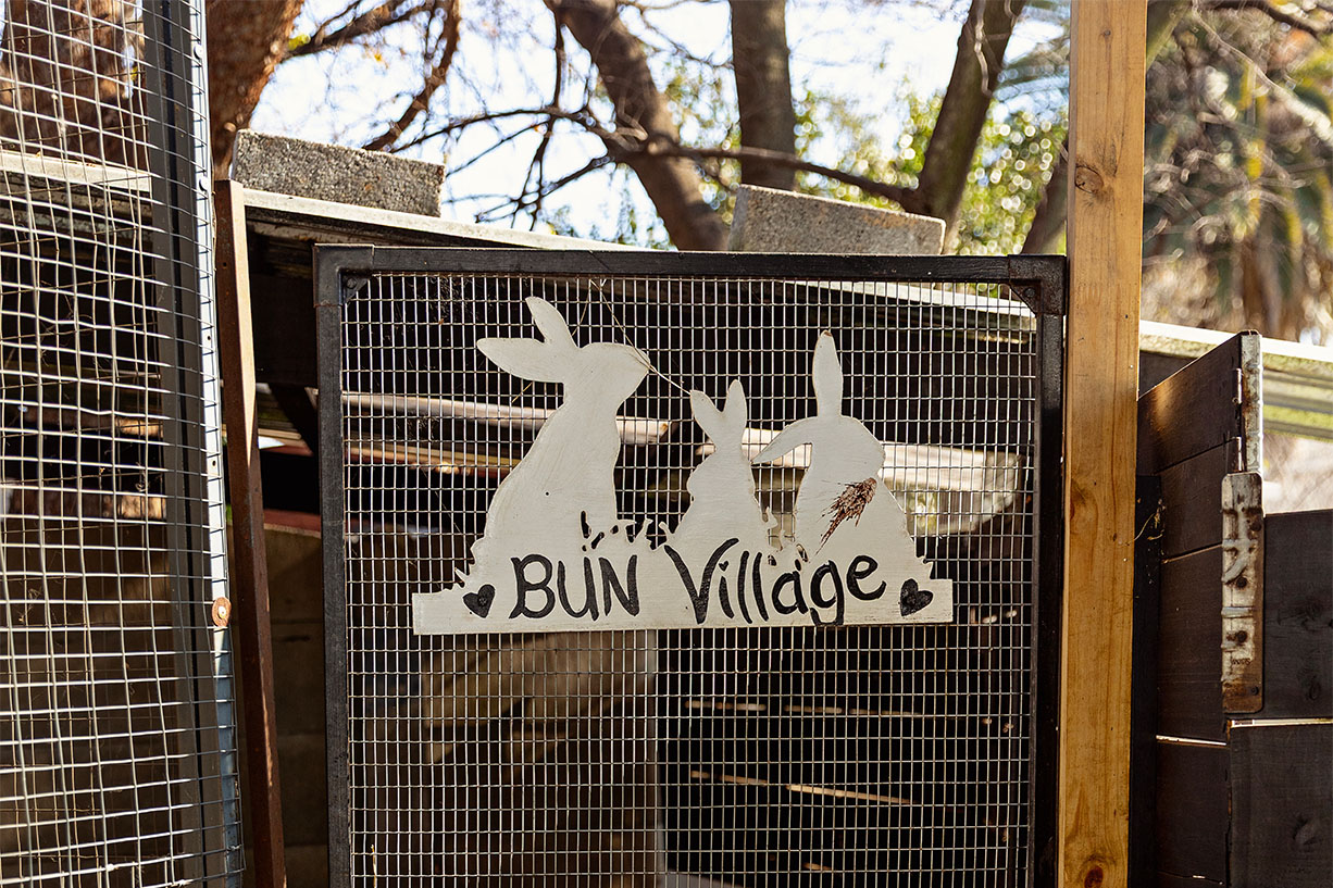 A metal gate featuring rabbit silhouettes marking the entrance to the Bun Village play area at The Robin House in Johannesburg.