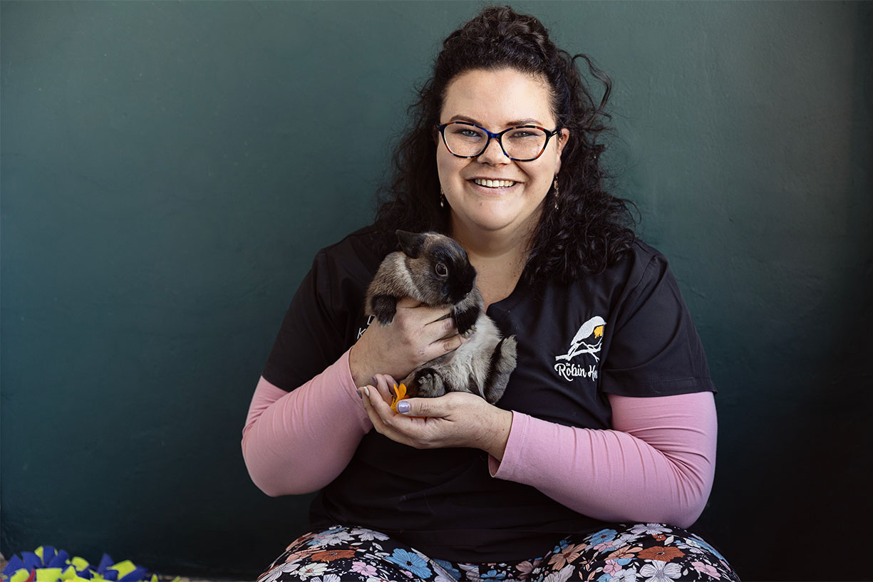 Veterinary Director Dr. Leigh smiling while holding a small rabbit guest at the exotic pet hotel in Benoni.